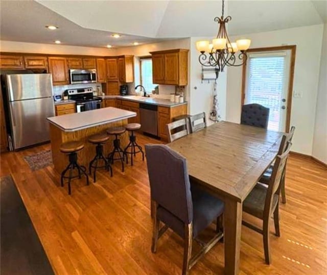 1720 SE Kenwood Dr, Blue Springs, MO 64014 - dining room featuring lofted ceiling, a chandelier, wood finished floors, and recessed lighting
