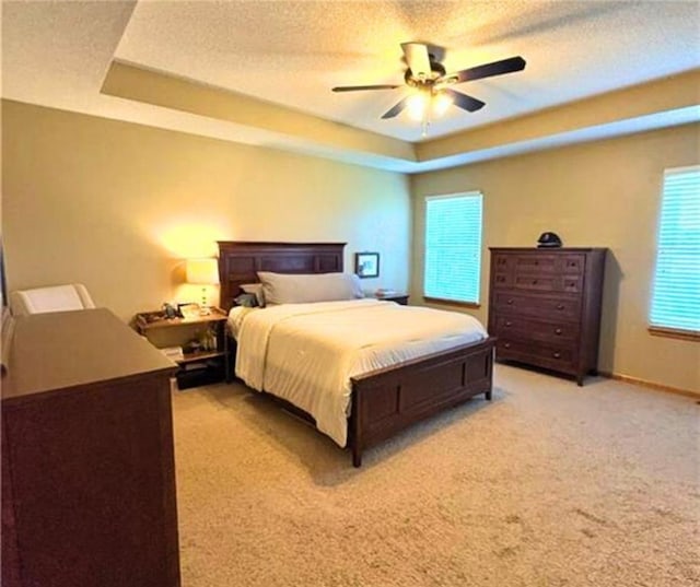 1720 SE Kenwood Dr, Blue Springs, MO 64014 - bedroom with a tray ceiling, light carpet, a ceiling fan, and a textured ceiling