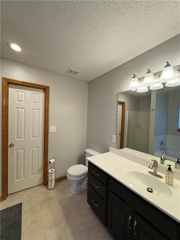 1720 SE Kenwood Dr, Blue Springs, MO 64014 - full bathroom featuring vanity and a textured ceiling