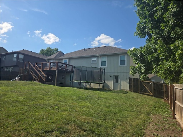 1720 SE Kenwood Dr, Blue Springs, MO 64014 - rear view of house featuring a trampoline, a fenced backyard, a deck, and stairs