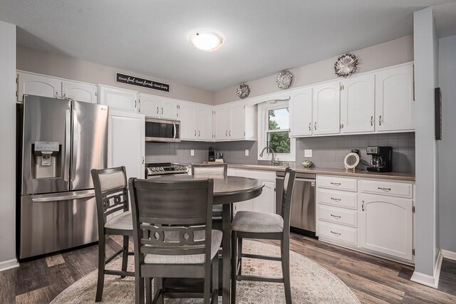 15714 Leavenworth Rd, Basehor, KS 66007 - kitchen featuring appliances with stainless steel finishes, backsplash, and white cabinets