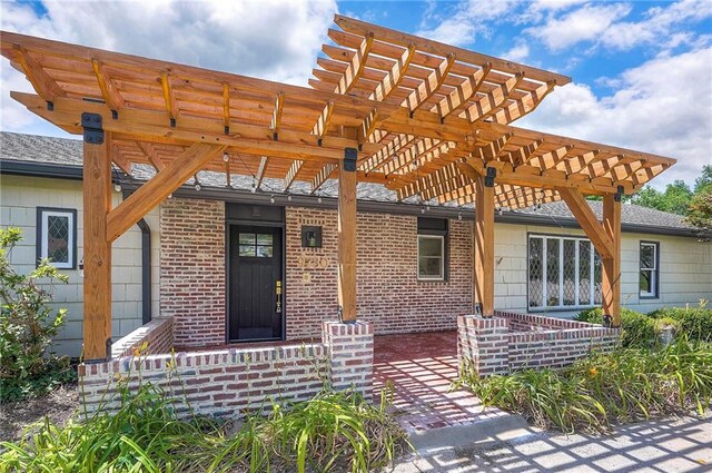 9730 State Line Rd, Leawood, KS 66206 - doorway to property featuring a pergola, brick siding, and a shingled roof