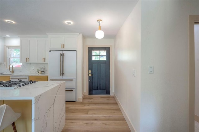 9730 State Line Rd, Leawood, KS 66206 - kitchen with white built in fridge, light wood finished floors, stainless steel gas stovetop, healthy amount of natural light, and recessed lighting