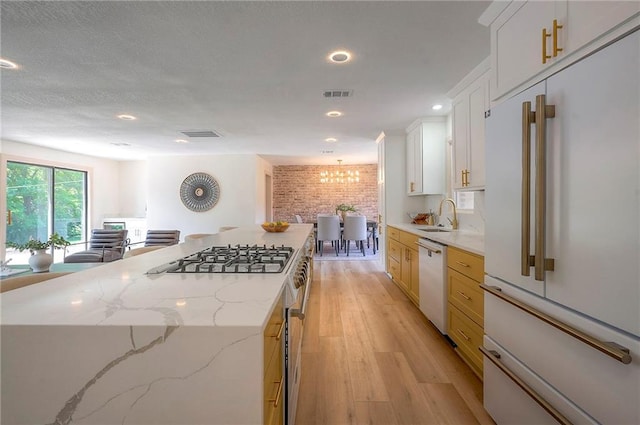 9730 State Line Rd, Leawood, KS 66206 - kitchen with white appliances, light wood-style floors, light stone countertops, recessed lighting, and white cabinetry