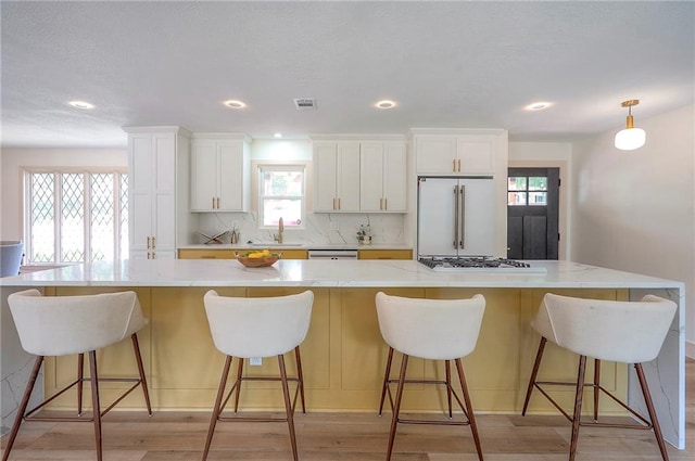 9730 State Line Rd, Leawood, KS 66206 - kitchen featuring stainless steel appliances, a spacious island, white cabinetry, decorative backsplash, and recessed lighting