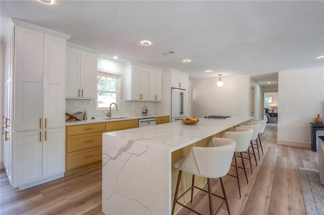 9730 State Line Rd, Leawood, KS 66206 - kitchen featuring white appliances, light wood-style flooring, decorative backsplash, white cabinets, and a large island