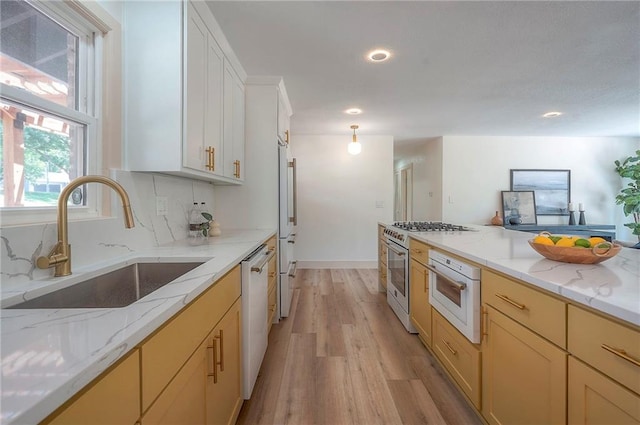 9730 State Line Rd, Leawood, KS 66206 - kitchen featuring white appliances, light wood-style floors, tasteful backsplash, light stone counters, and recessed lighting