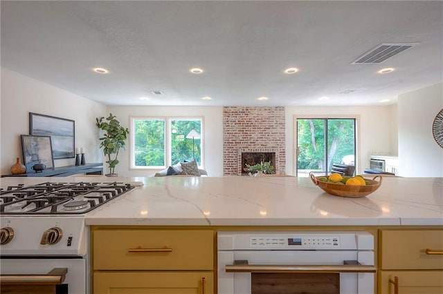 9730 State Line Rd, Leawood, KS 66206 - kitchen featuring white range with gas cooktop, oven, open floor plan, recessed lighting, and light stone counters