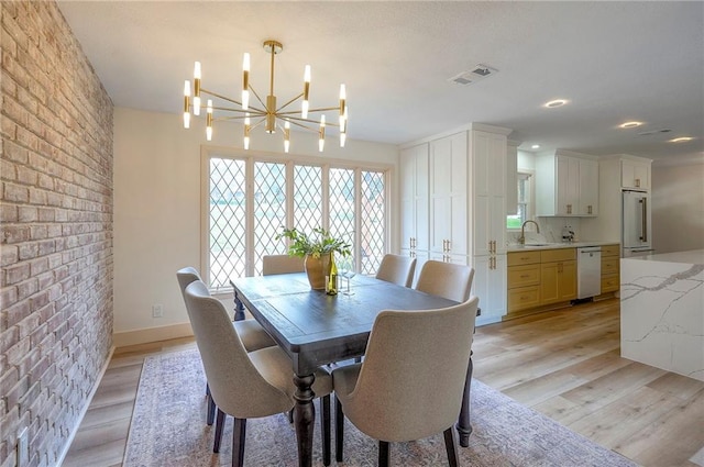9730 State Line Rd, Leawood, KS 66206 - dining room featuring light wood finished floors, a chandelier, and brick wall