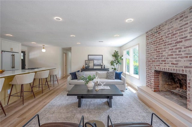 9730 State Line Rd, Leawood, KS 66206 - living area featuring light wood-style flooring, recessed lighting, and a brick fireplace