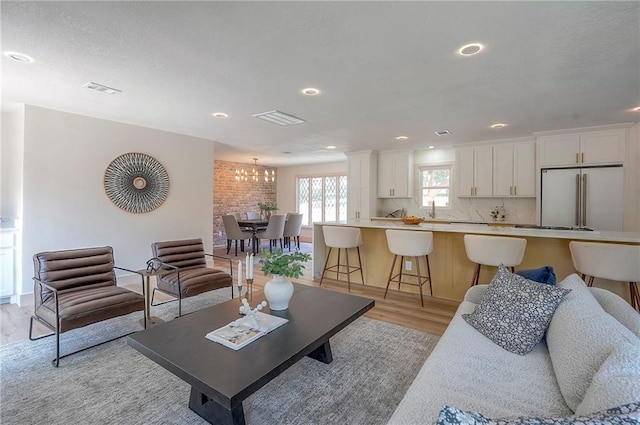 9730 State Line Rd, Leawood, KS 66206 - living room featuring light wood-style flooring, recessed lighting, and a chandelier