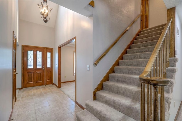 11512 Hadley St, Overland Park, KS 66210 - entrance foyer featuring stairway, a high ceiling, a chandelier, and light tile patterned floors