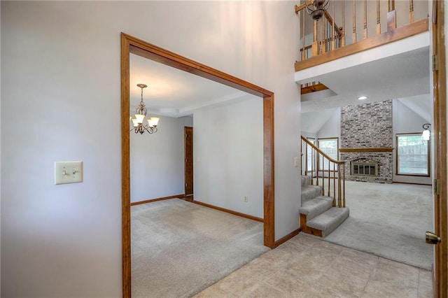 11512 Hadley St, Overland Park, KS 66210 - stairway featuring carpet, a chandelier, a large fireplace, and a towering ceiling