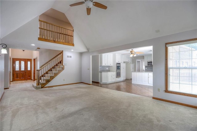 11512 Hadley St, Overland Park, KS 66210 - unfurnished living room featuring ceiling fan, light colored carpet, healthy amount of natural light, and high vaulted ceiling