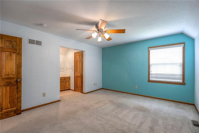 11512 Hadley St, Overland Park, KS 66210 - unfurnished bedroom featuring light carpet, lofted ceiling, a textured ceiling, ensuite bath, and a ceiling fan