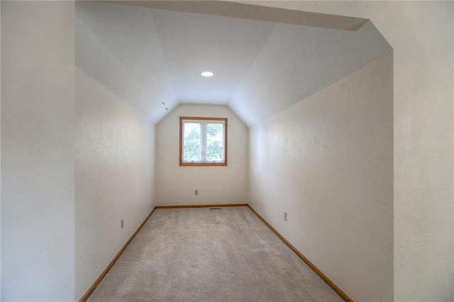 11512 Hadley St, Overland Park, KS 66210 - bonus room with vaulted ceiling, a textured wall, and light colored carpet