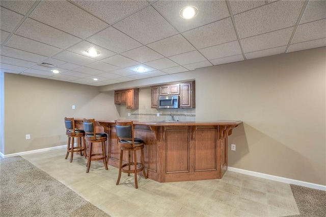 11512 Hadley St, Overland Park, KS 66210 - indoor wet bar featuring stainless steel microwave, recessed lighting, light colored carpet, and a drop ceiling