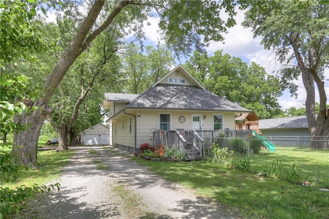 2509 E 4th St, Pittsburg, KS 66762 - bungalow-style house with a playground, an outdoor structure, a shingled roof, and a detached garage