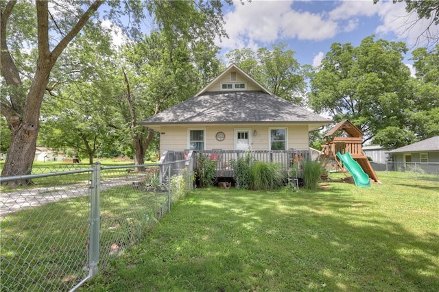 2509 E 4th St, Pittsburg, KS 66762 - rear view of house featuring a playground, a fenced backyard, a shingled roof, and a deck