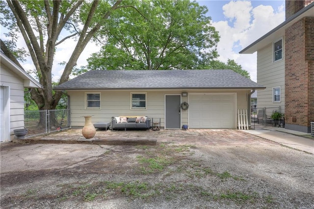 2509 E 4th St, Pittsburg, KS 66762 - view of front facade featuring an outdoor living space, asphalt driveway, a garage, a shingled roof, and an outbuilding