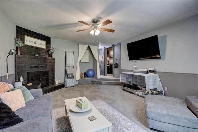 2509 E 4th St, Pittsburg, KS 66762 - carpeted living room featuring ceiling fan, a brick fireplace, and a textured ceiling