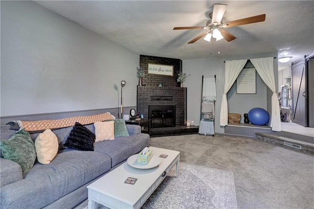 2509 E 4th St, Pittsburg, KS 66762 - living room featuring light carpet, a ceiling fan, a textured ceiling, and a brick fireplace