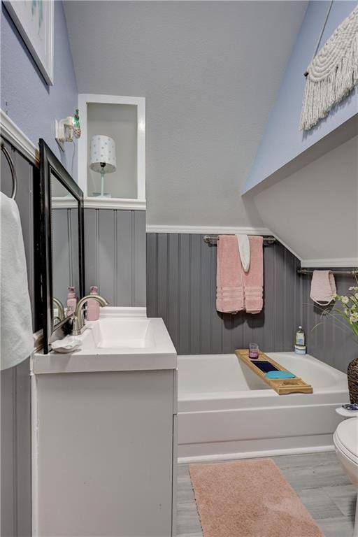 2509 E 4th St, Pittsburg, KS 66762 - full bath with a garden tub, vanity, wood finished floors, and vaulted ceiling