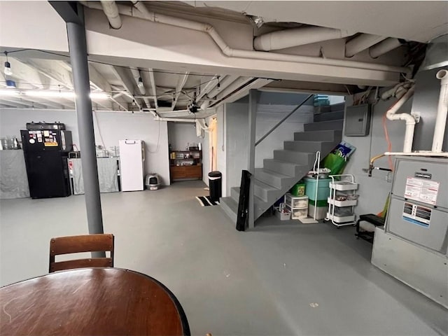 2509 E 4th St, Pittsburg, KS 66762 - unfinished below grade area with electric panel, freestanding refrigerator, and stairs