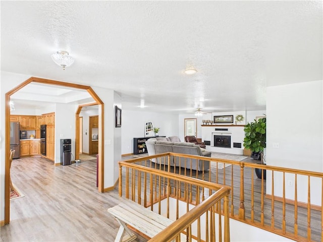529 SE Dd Hwy, Warrensburg, MO 64093 - corridor with a textured ceiling, light wood-style flooring, and arched walkways