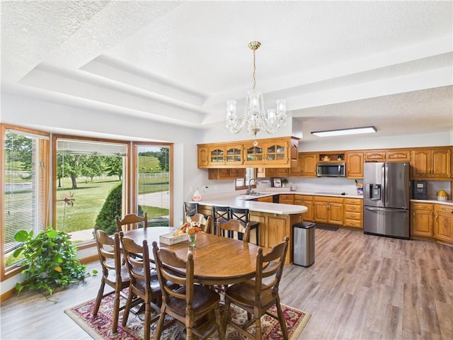 529 SE Dd Hwy, Warrensburg, MO 64093 - dining room with a tray ceiling, a chandelier, light wood-style floors, and a textured ceiling