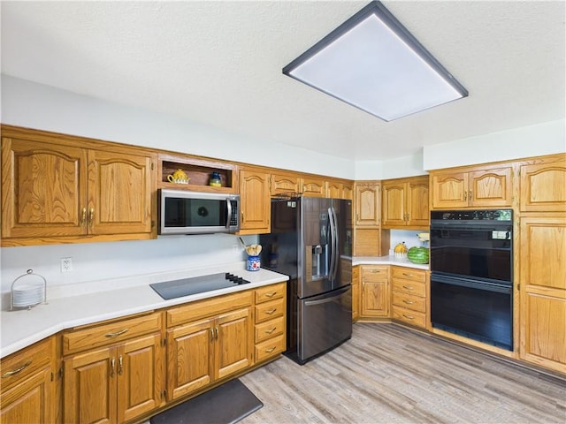 529 SE Dd Hwy, Warrensburg, MO 64093 - kitchen featuring black appliances, light countertops, and brown cabinets
