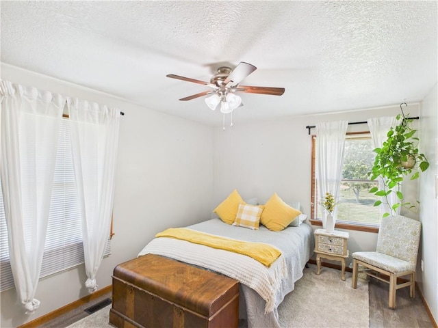 529 SE Dd Hwy, Warrensburg, MO 64093 - bedroom featuring a ceiling fan, a textured ceiling, and wood finished floors