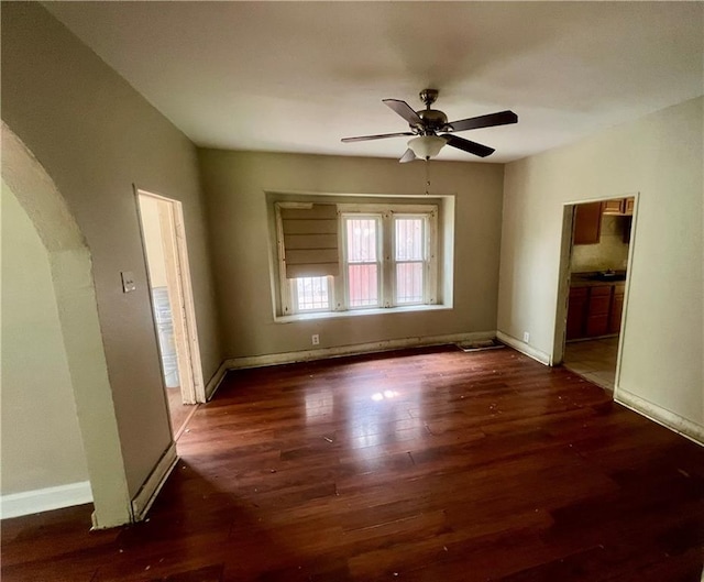 707 Georgia Ave, Kansas City, KS 66101 - unfurnished living room featuring arched walkways, a ceiling fan, and wood finished floors