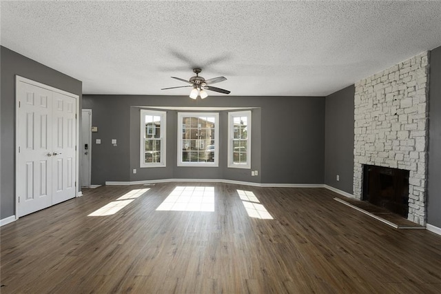 14011 Dunbar Ct, Grandview, MO 64030 - unfurnished living room with a ceiling fan, a stone fireplace, a textured ceiling, and wood finished floors