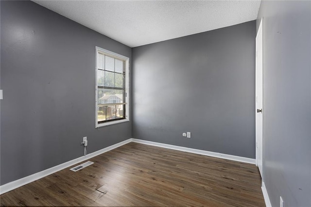 14011 Dunbar Ct, Grandview, MO 64030 - spare room featuring dark wood-style floors and a textured ceiling