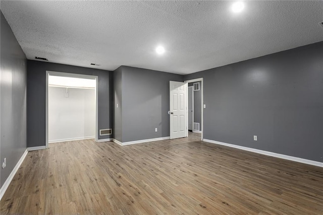 14011 Dunbar Ct, Grandview, MO 64030 - spare room featuring a textured ceiling and wood finished floors