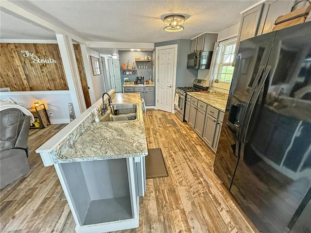 26240 Lakeview Dr, Maryville, MO 64468 - kitchen featuring stainless steel appliances, gray cabinetry, light wood finished floors, light stone counters, and a textured ceiling