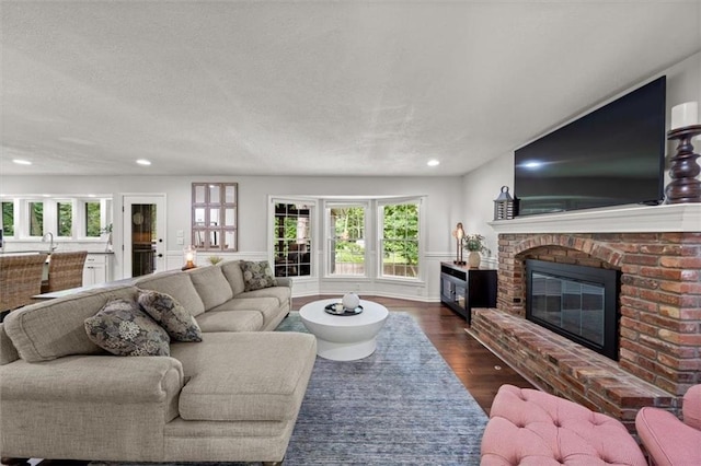 6710 Broadmoor St, Overland Park, KS 66204 - living area featuring a fireplace, dark wood-type flooring, plenty of natural light, recessed lighting, and a textured ceiling