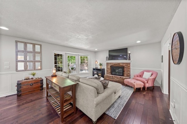 6710 Broadmoor St, Overland Park, KS 66204 - living area with a textured ceiling, dark wood-type flooring, a fireplace, a wainscoted wall, and a decorative wall