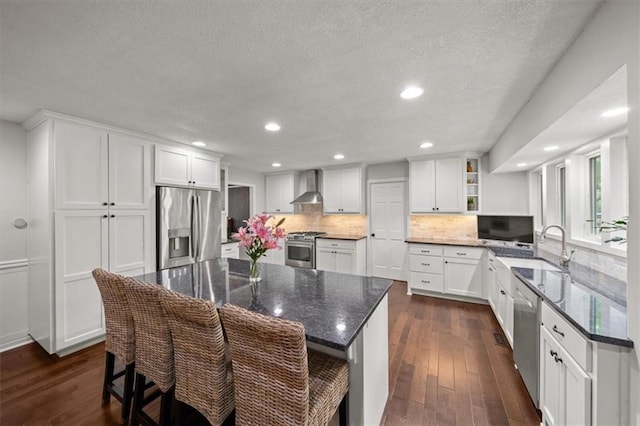6710 Broadmoor St, Overland Park, KS 66204 - kitchen with stainless steel appliances, wall chimney exhaust hood, dark wood-style floors, open shelves, and a textured ceiling