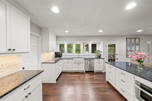 6710 Broadmoor St, Overland Park, KS 66204 - kitchen with stainless steel dishwasher, recessed lighting, backsplash, dark wood finished floors, and dark stone countertops