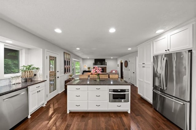 6710 Broadmoor St, Overland Park, KS 66204 - kitchen with stainless steel appliances, dark wood-style flooring, dark stone countertops, white cabinetry, and recessed lighting