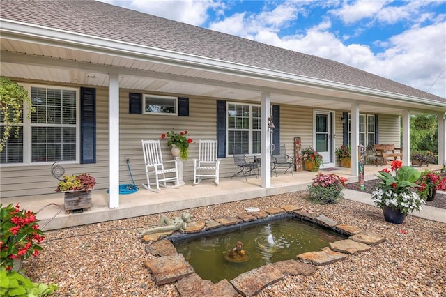 23708 S Southcrest Dr, Peculiar, MO 64078 - rear view of property with a porch, a garden pond, and roof with shingles