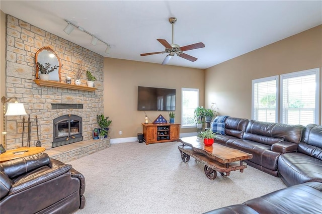23708 S Southcrest Dr, Peculiar, MO 64078 - carpeted living room with track lighting, a ceiling fan, plenty of natural light, and a stone fireplace