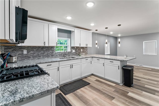 5510 Lafayette Ave, Kansas City, KS 66104 - kitchen featuring a peninsula, white cabinetry, recessed lighting, backsplash, and light wood-style flooring