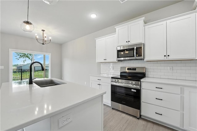 3319 N 109th Ter, Kansas City, KS 66109 - kitchen featuring appliances with stainless steel finishes, light countertops, a chandelier, and backsplash