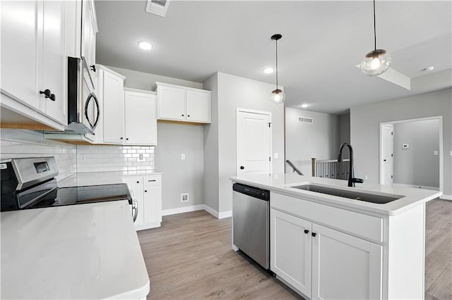 3319 N 109th Ter, Kansas City, KS 66109 - kitchen with appliances with stainless steel finishes, light wood-style floors, decorative backsplash, white cabinets, and recessed lighting