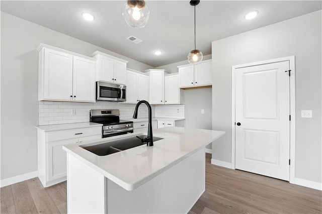 3319 N 109th Ter, Kansas City, KS 66109 - kitchen with stainless steel appliances, light wood-style floors, decorative backsplash, white cabinets, and light countertops