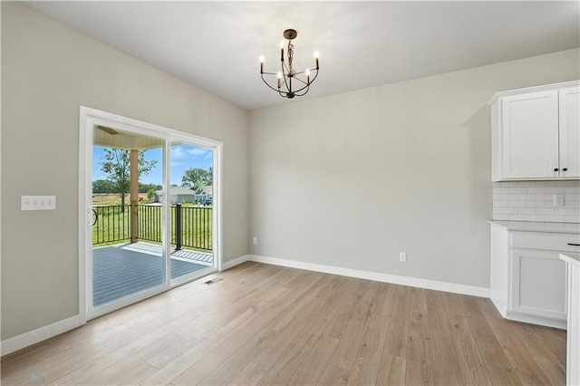3319 N 109th Ter, Kansas City, KS 66109 - unfurnished dining area with a chandelier and light wood-style floors