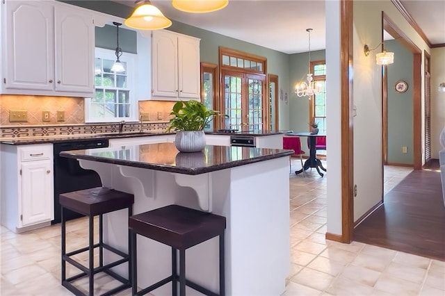 13009 Fontana St, Leawood, KS 66209 - kitchen featuring dishwasher, a center island, white cabinetry, and tasteful backsplash